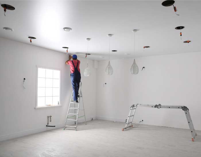 Electrical-Services Electrician installing energy-efficient lighting in a Tulare business office